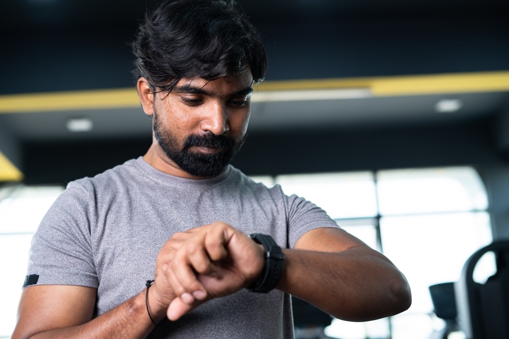 Low,Angle,View,Of,Young,Man,Monitoring,Calories,Or,Heart Self-Monitoring for Success